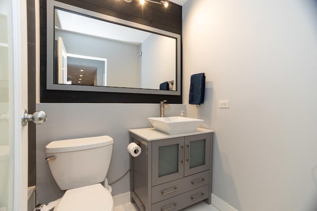 bathroom featuring vanity, toilet, and baseboards
