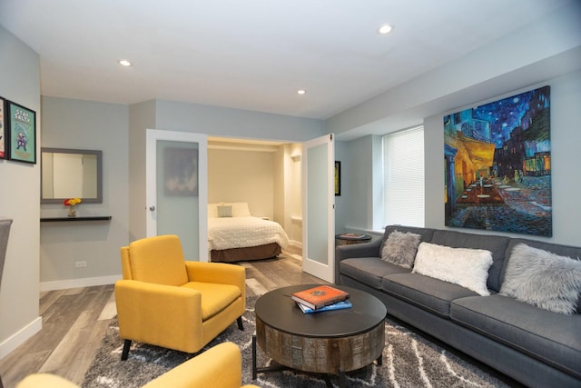 living room with wood finished floors, baseboards, and recessed lighting