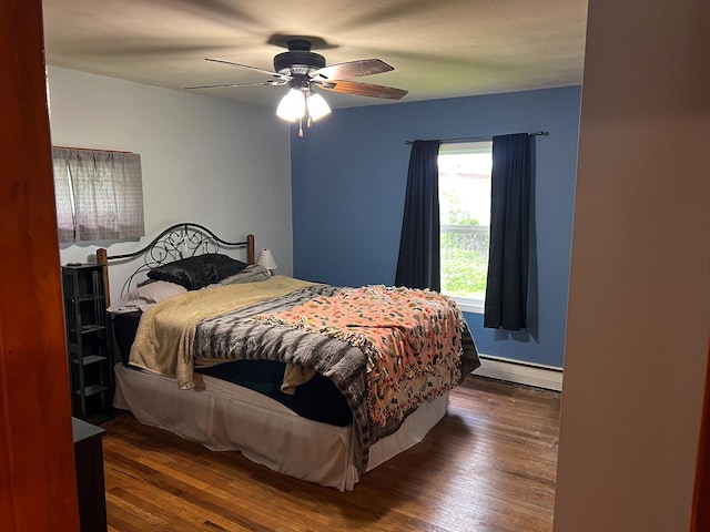 bedroom with dark wood-style flooring, a ceiling fan, and baseboard heating