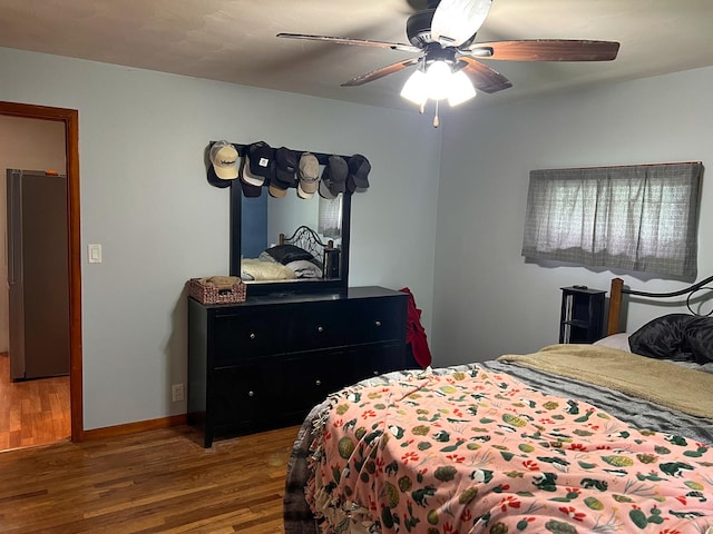 bedroom featuring a ceiling fan, baseboards, and wood finished floors