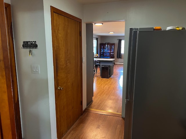 corridor with a baseboard radiator and light wood-style flooring