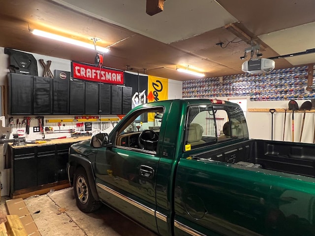 garage with a workshop area and a garage door opener