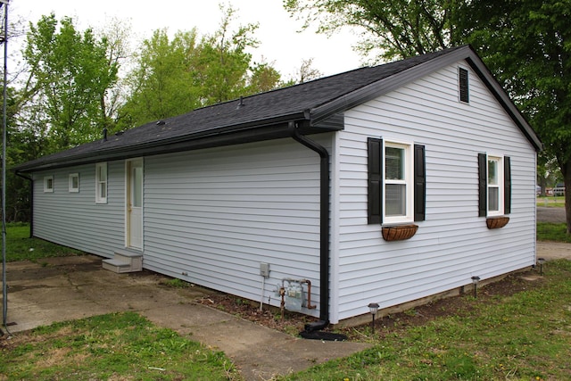 view of property exterior featuring entry steps and a shingled roof