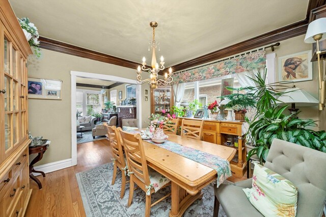 1306 Highland Ave, Berwyn, IL 60402 - dining space with crown molding, a chandelier, and light wood-style floors