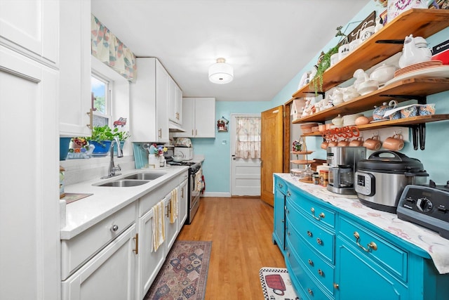 1306 Highland Ave, Berwyn, IL 60402 - kitchen with gas stove, open shelves, white cabinetry, blue cabinetry, and light wood finished floors
