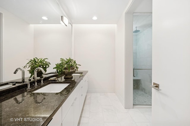 bathroom featuring marble look tiles, walk in shower, double vanity, baseboards, and recessed lighting