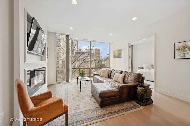 living room featuring wood finished floors, recessed lighting, expansive windows, and baseboards