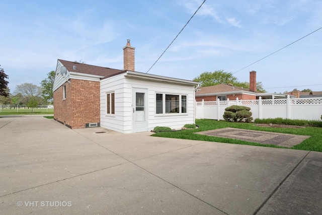 8223 N Washington St, Niles, IL 60714 - view of side of property featuring a chimney, fence, brick siding, and a patio