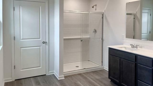 full bathroom featuring baseboards, a shower stall, and wood finished floors