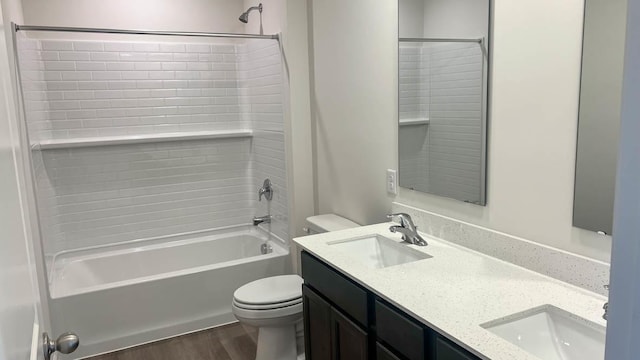 full bath featuring a sink, shower / bathing tub combination, toilet, and wood finished floors