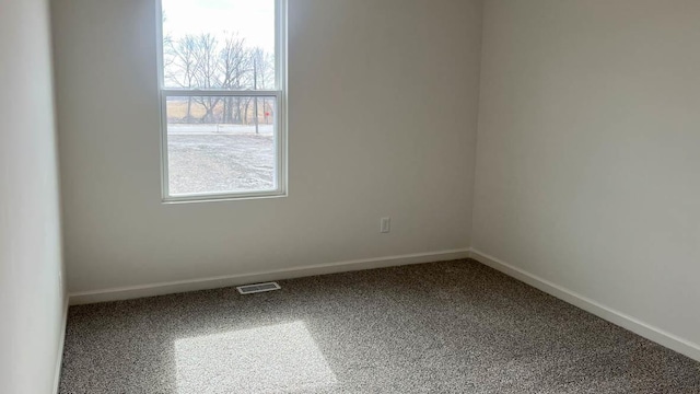 unfurnished room with carpet floors, baseboards, and visible vents