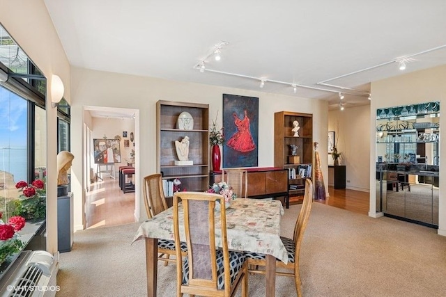 dining space with attic access, carpet, and track lighting