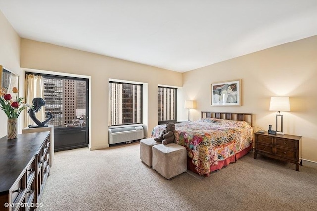 bedroom featuring light colored carpet, an AC wall unit, and access to outside