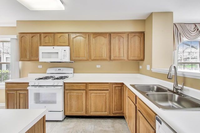 kitchen with white appliances, light countertops, and a sink