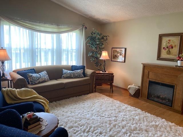 300 Marquette Ln, Spring Valley, IL 61362 - living area featuring a textured ceiling, wood finished floors, a glass covered fireplace, and baseboards