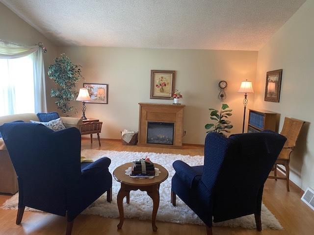 300 Marquette Ln, Spring Valley, IL 61362 - living area featuring light wood finished floors, a textured ceiling, a fireplace, and baseboards