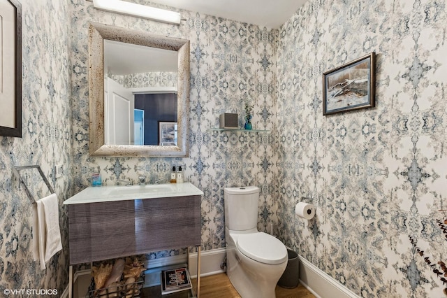 900 N Kingsbury St Unit 1150, Chicago, IL 60610 - half bath with toilet, vanity, wallpapered walls, and wood finished floors