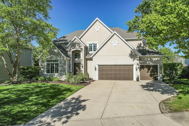 2411 Williamstown Ct, Naperville, IL 60564 - view of front facade with stucco siding, driveway, a front yard, and an attached garage
