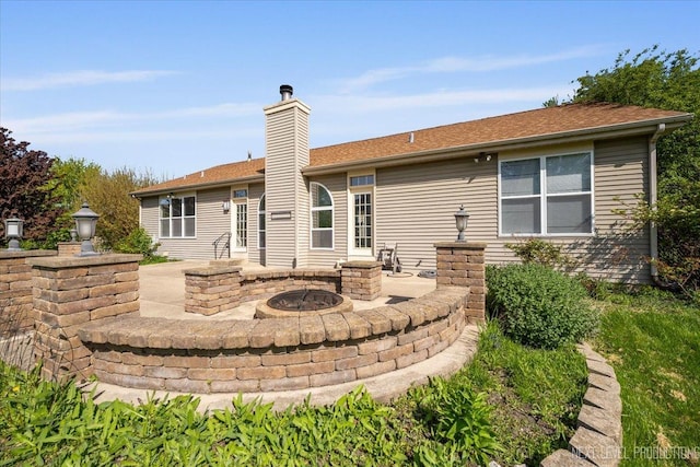 rear view of property with an outdoor fire pit, a patio, and a chimney