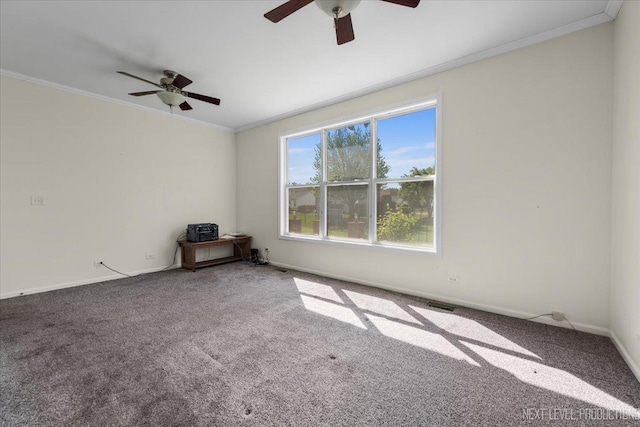 carpeted spare room featuring a ceiling fan, crown molding, and baseboards