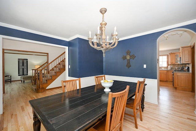 1408 Ambleside Cir, Naperville, IL 60540 - dining space featuring light wood-style flooring, a chandelier, arched walkways, stairs, and crown molding