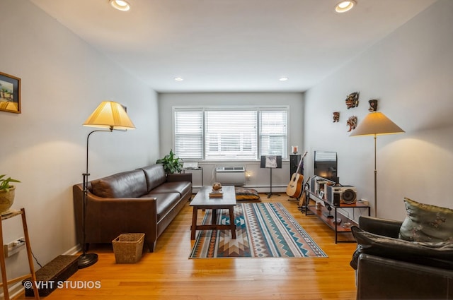 living area with recessed lighting, light wood-style flooring, and a baseboard radiator
