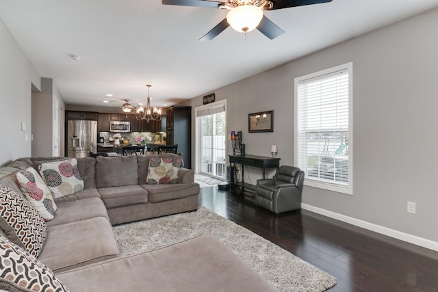 living room with dark wood-style flooring, ceiling fan with notable chandelier, baseboards, and recessed lighting