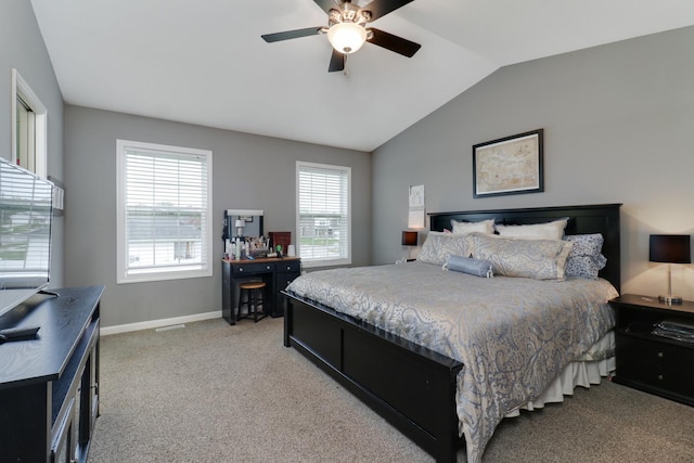 bedroom with light colored carpet, lofted ceiling, baseboards, and ceiling fan