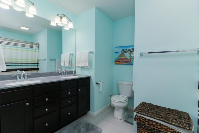 full bathroom featuring double vanity, toilet, tile patterned flooring, and a sink