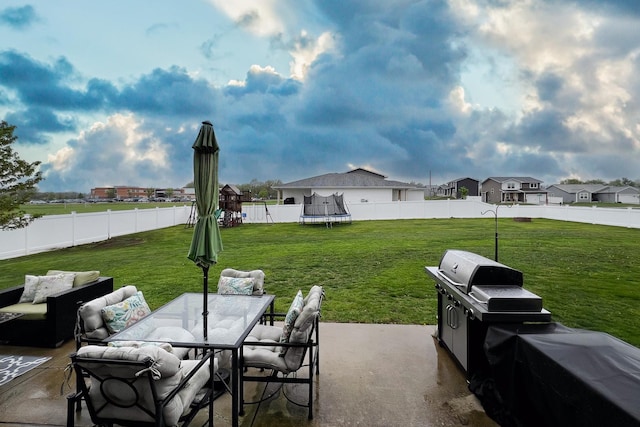 view of patio with a trampoline, a residential view, outdoor dining space, a fenced backyard, and outdoor lounge area