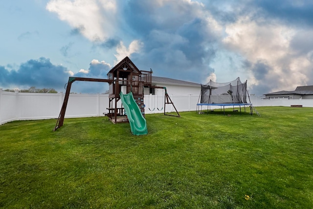 view of jungle gym with a yard, a trampoline, and a fenced backyard