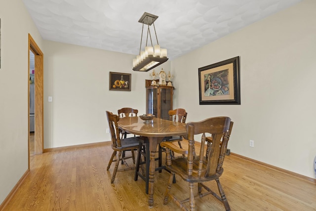 11920 Hunterston Dr, Caledonia, IL 61011 - dining space with light wood finished floors, baseboards, and a notable chandelier