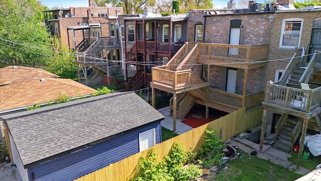 6430 S Eberhart Ave, Chicago, IL 60637 - rear view of house with stairway, brick siding, a chimney, and fence