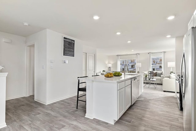 6600 Linden Trl Unit F, Wonder Lake, IL 60097 - kitchen with light wood-type flooring, a sink, open floor plan, stainless steel appliances, and an island with sink