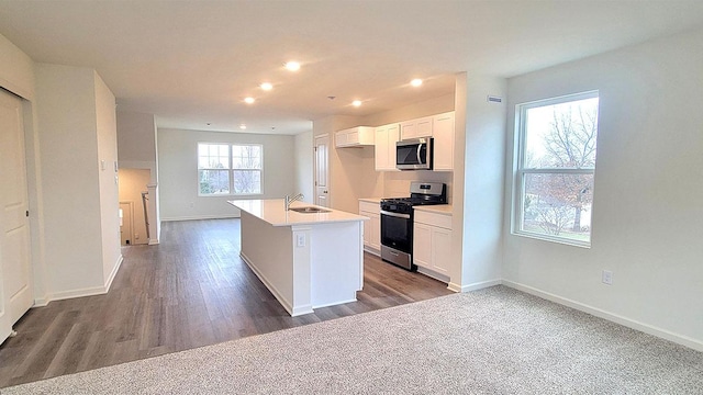 6600 Linden Trl Unit F, Wonder Lake, IL 60097 - kitchen with a sink, gas range oven, white cabinetry, a center island with sink, and stainless steel microwave