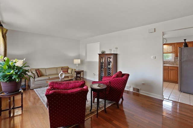 living area with light wood-type flooring and baseboards