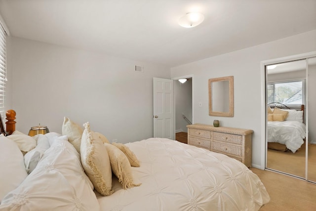 bedroom with light carpet and a closet
