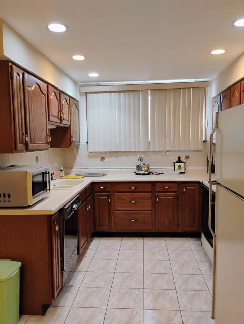 8856 Plainfield Rd, Brookfield, IL 60513 - kitchen featuring freestanding refrigerator, light tile patterned floors, black dishwasher, a sink, and light countertops