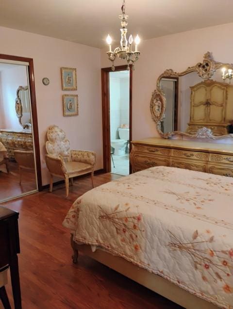 8856 Plainfield Rd, Brookfield, IL 60513 - bedroom featuring an inviting chandelier, ensuite bathroom, and wood finished floors
