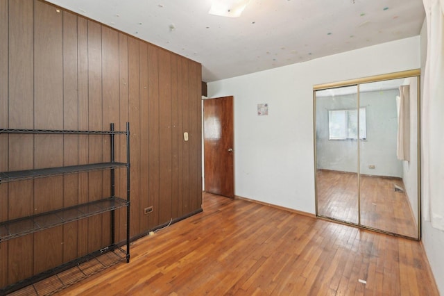 unfurnished bedroom featuring a closet and hardwood / wood-style floors