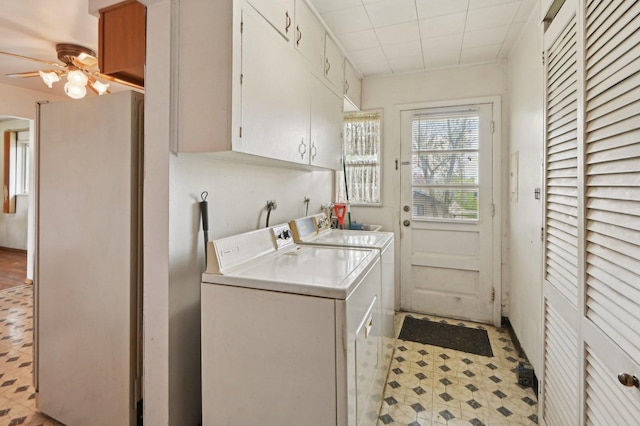 clothes washing area featuring ceiling fan, light floors, cabinet space, and independent washer and dryer