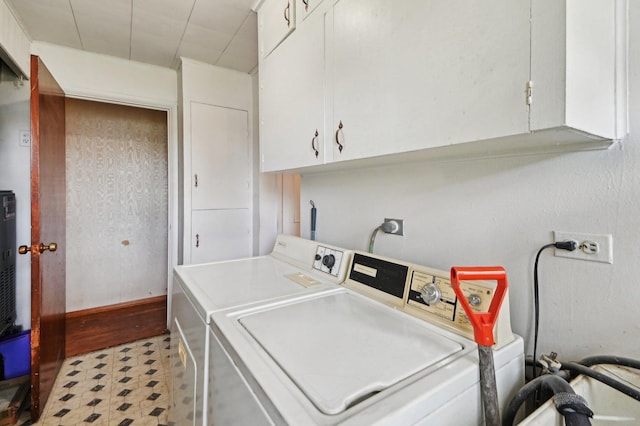 washroom featuring washer and clothes dryer, light floors, and cabinet space