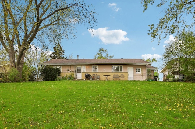 rear view of property featuring a lawn