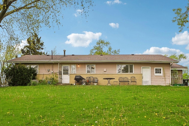 rear view of property featuring brick siding and a lawn