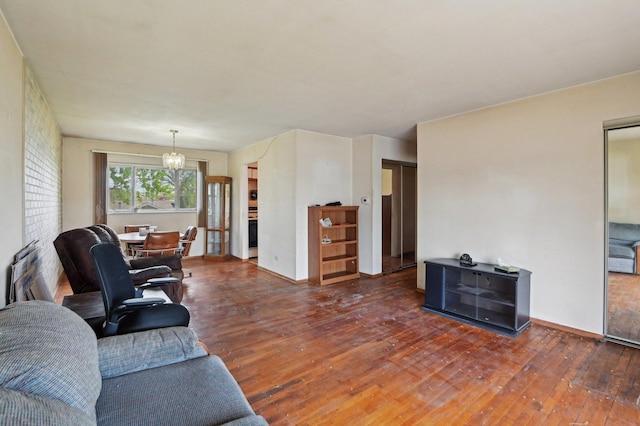 living area featuring a notable chandelier, baseboards, and hardwood / wood-style flooring