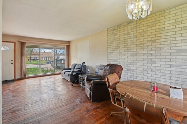 interior space featuring brick wall, a chandelier, and hardwood / wood-style floors