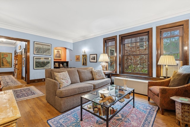 living room with arched walkways, radiator, ornamental molding, and wood finished floors