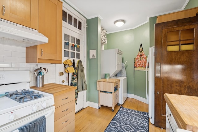 kitchen with under cabinet range hood, wood counters, crown molding, decorative backsplash, and white range with gas cooktop
