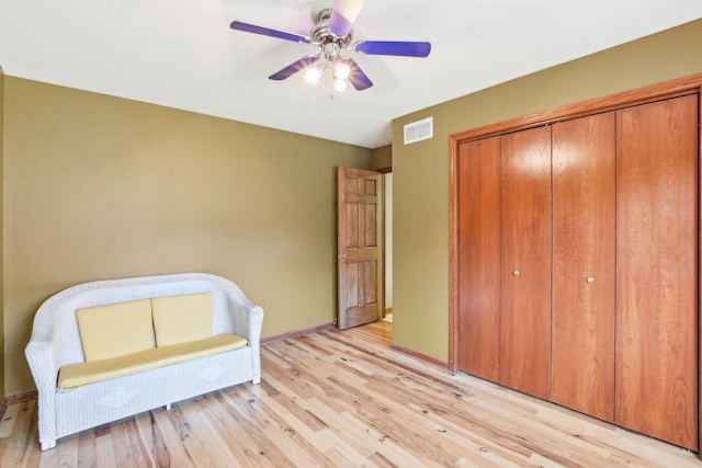 bedroom with light wood-style flooring, a closet, baseboards, and visible vents