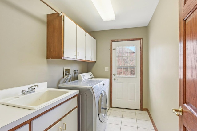 laundry room with light tile patterned floors, a sink, washing machine and dryer, and cabinet space
